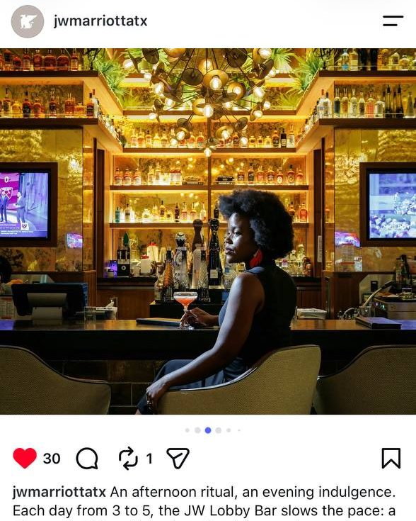 Client Posts — @jwmarriottatx feature of a guest at the JW Lobby Bar beneath the gold sputnik chandelier