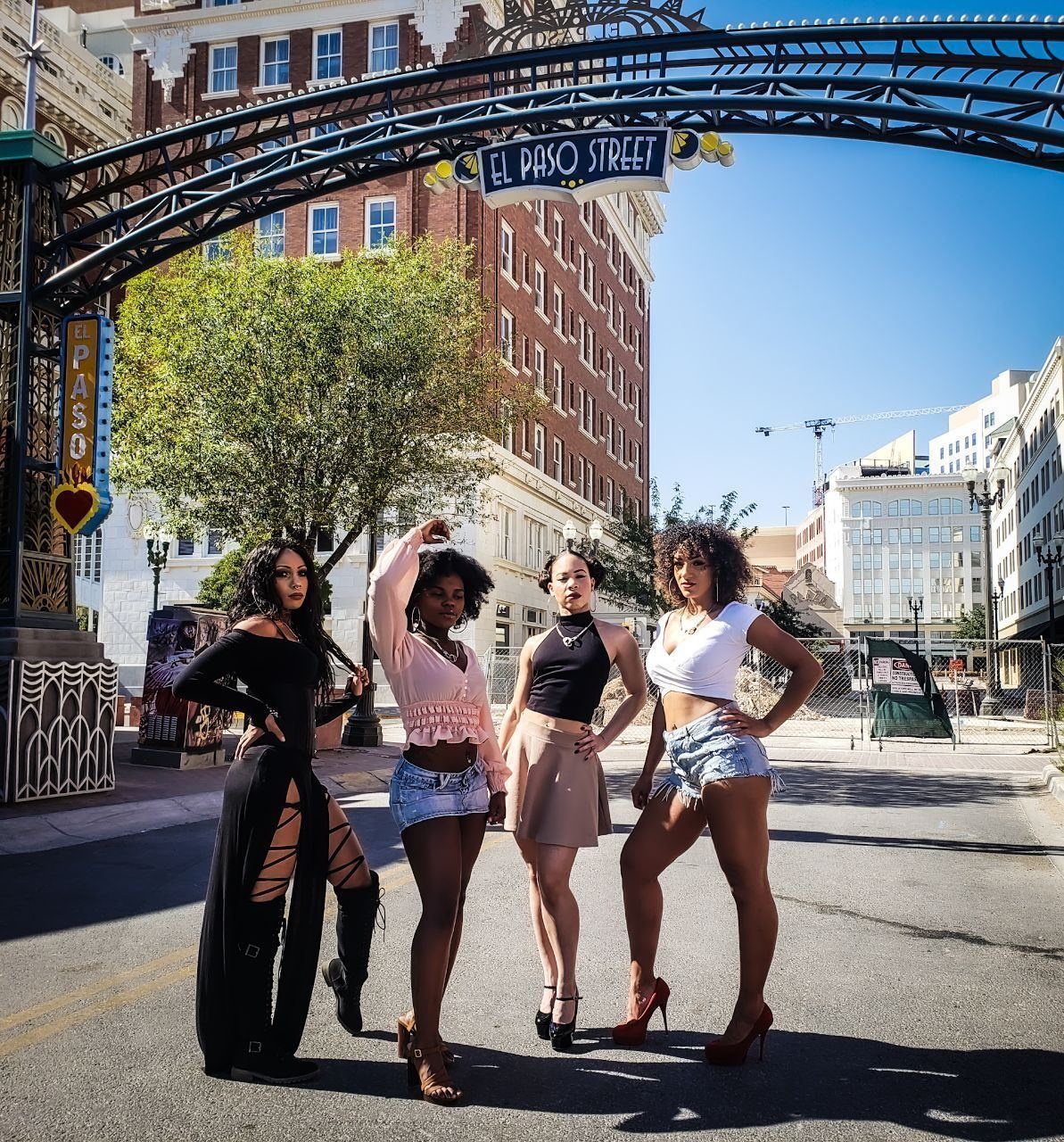 Events — Four brand ambassadors posing beneath the El Paso Street arch on a sunny downtown street