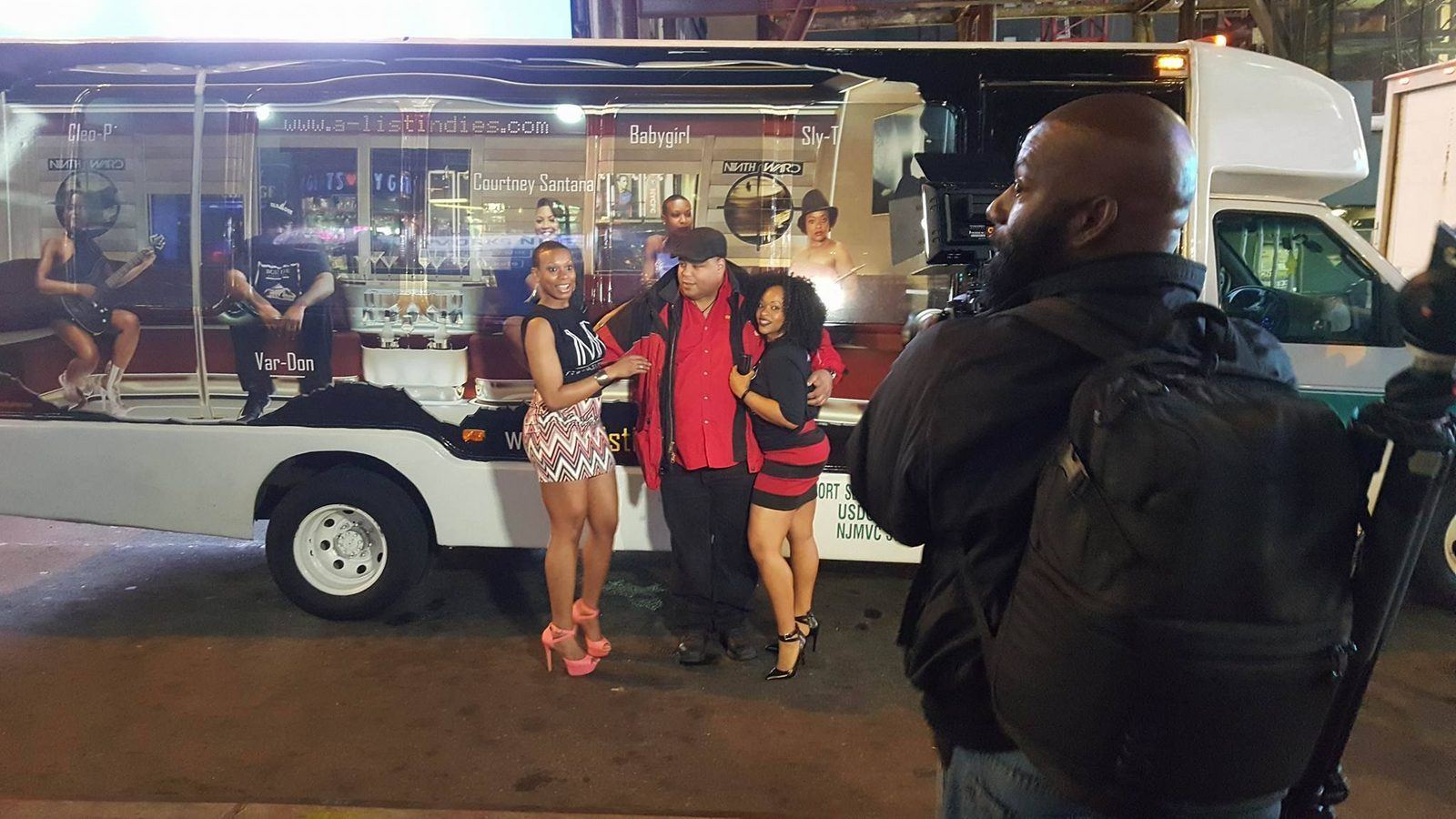Events — Videographer filming two brand ambassadors and a guest beside an A-List Indies wrapped shuttle at night