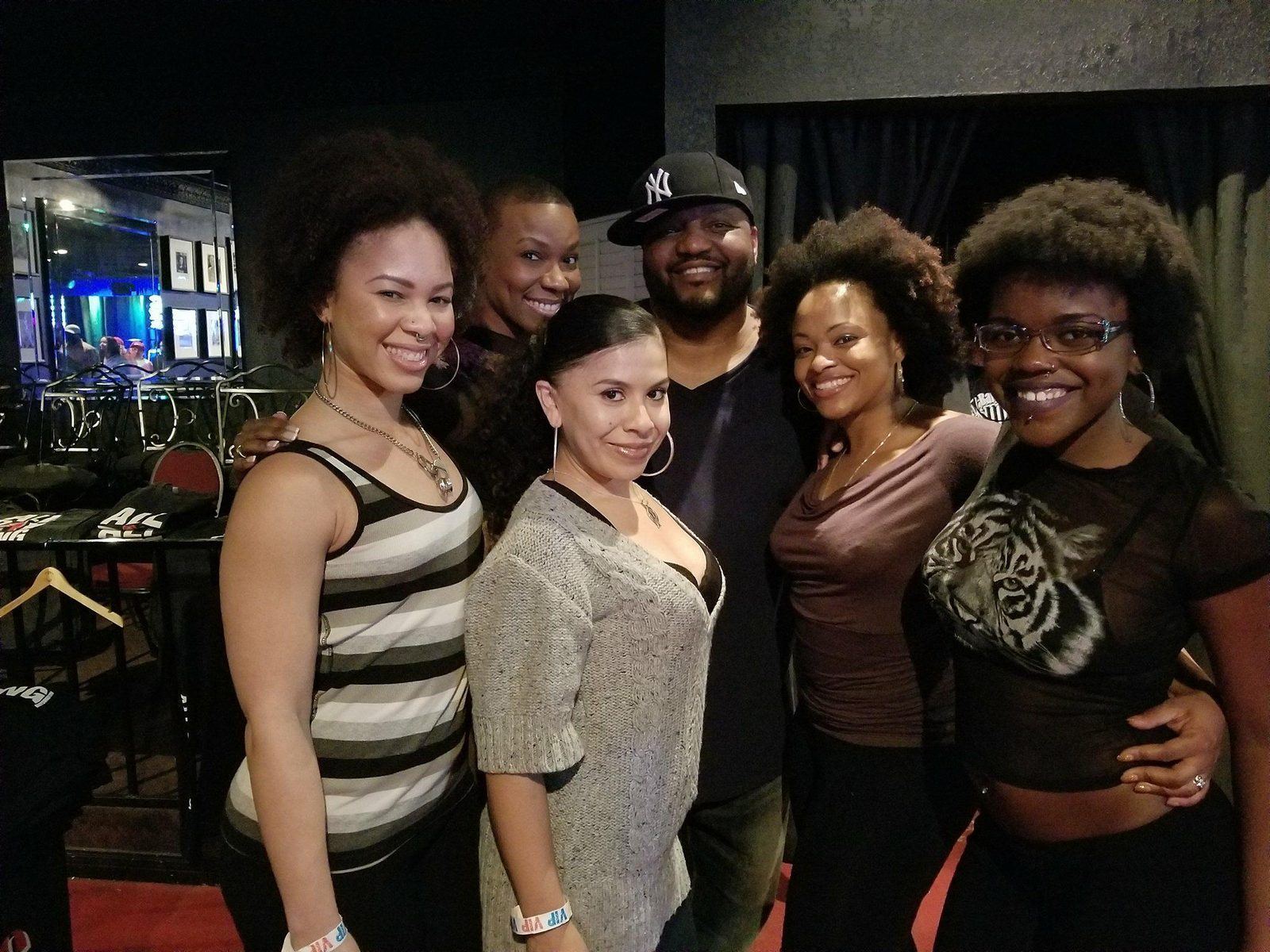 Events — Five brand ambassadors with VIP wristbands posing alongside a guest in an intimate club lounge