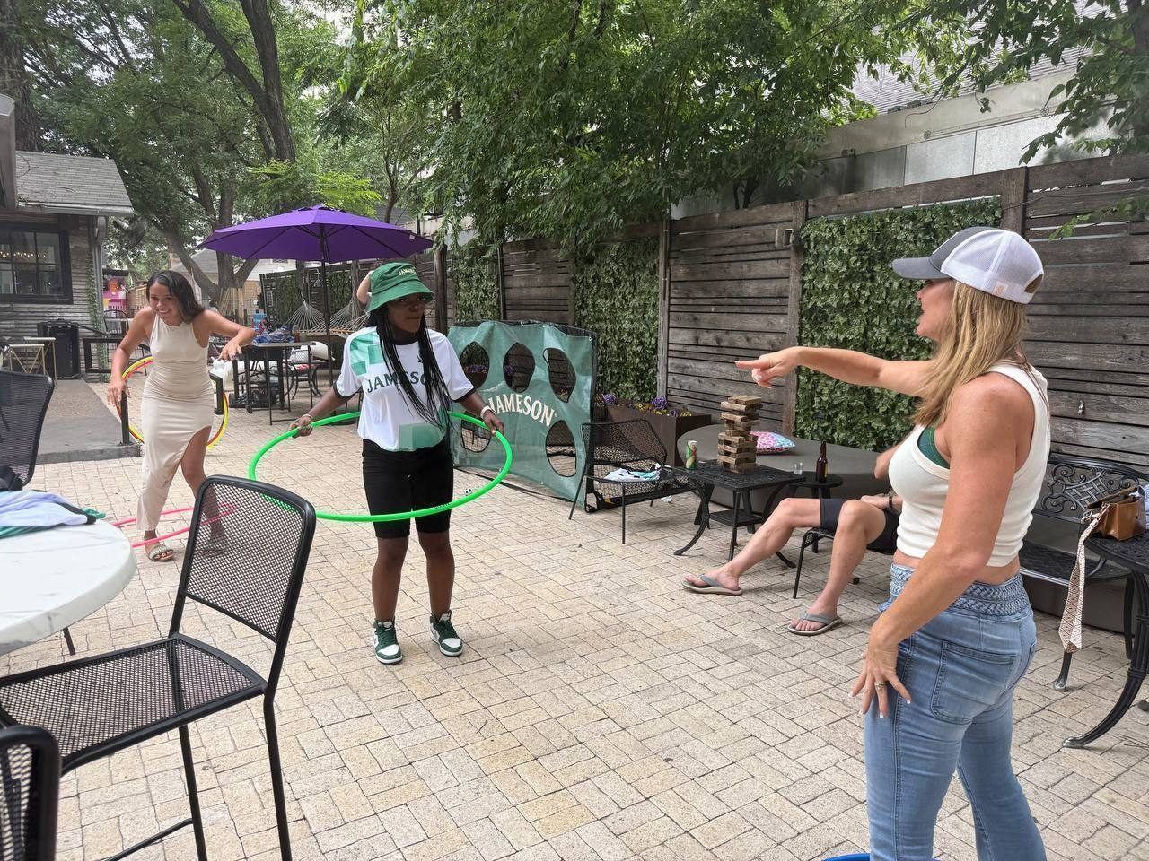 Events — Jameson patio activation with ambassador hula hooping alongside guests near branded soccer goal and giant Jenga