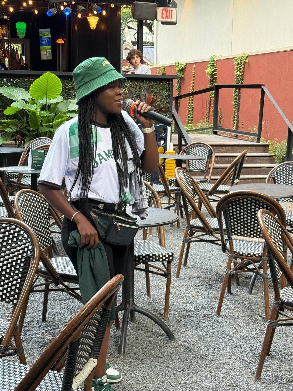 Events — Jameson brand ambassador on the microphone hosting patio games among bistro tables at an outdoor bar