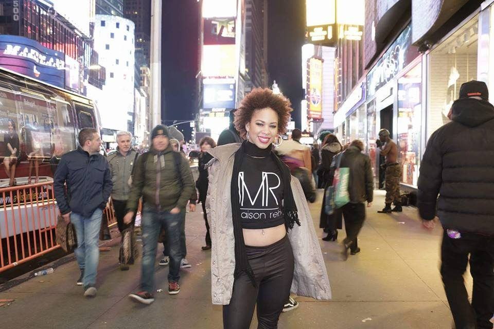 Events — Brand ambassador in a branded MR crop top posing on a bustling neon-lit city street at night