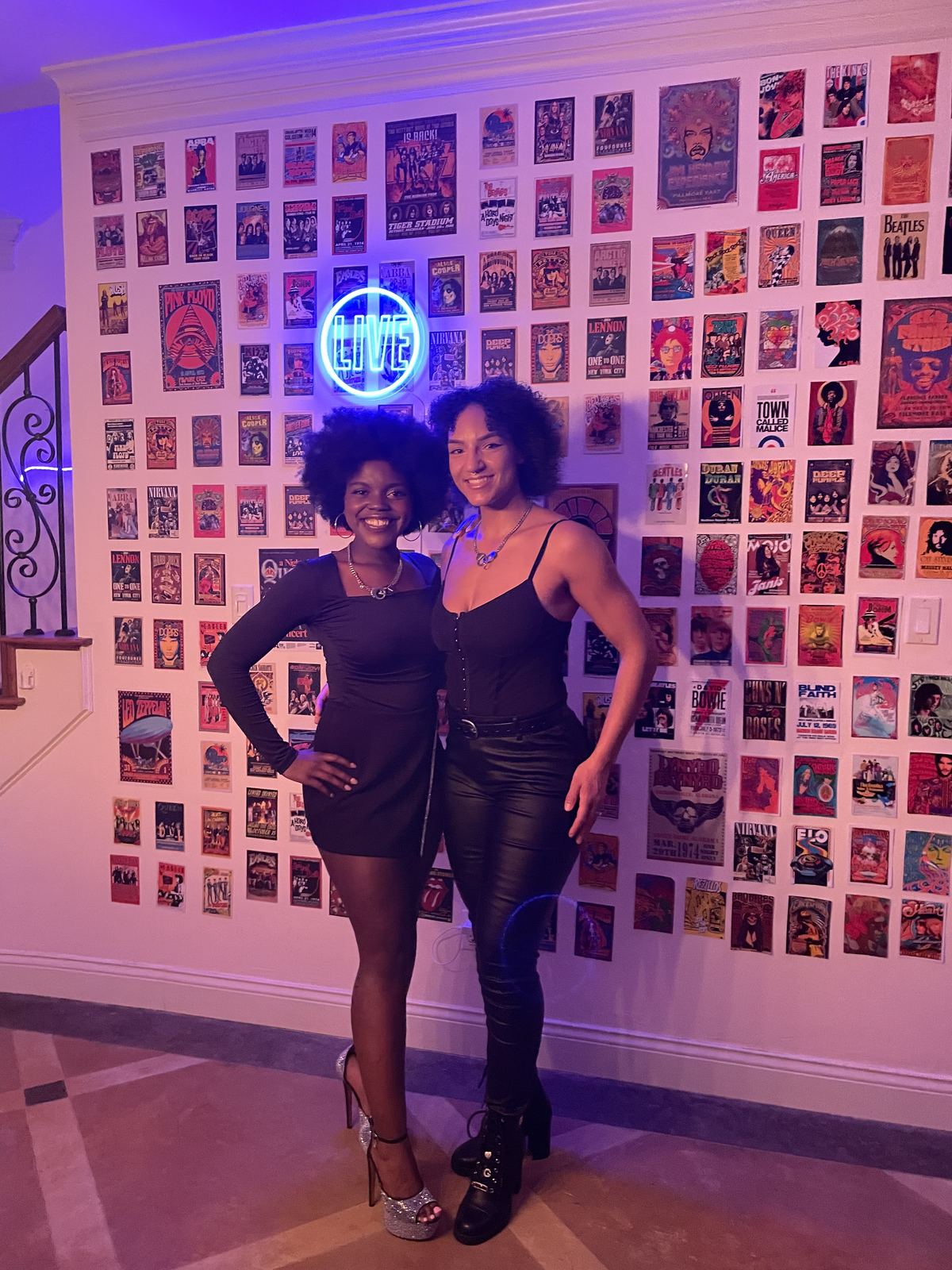 Events — Two brand ambassadors in black outfits posing beneath a neon LIVE sign on a vintage concert poster wall