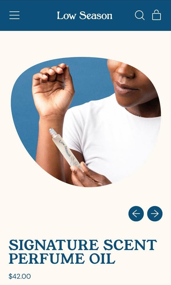 Influencer Work — Low Season Signature Scent Perfume Oil roller shown against a blue backdrop on the brand's product page