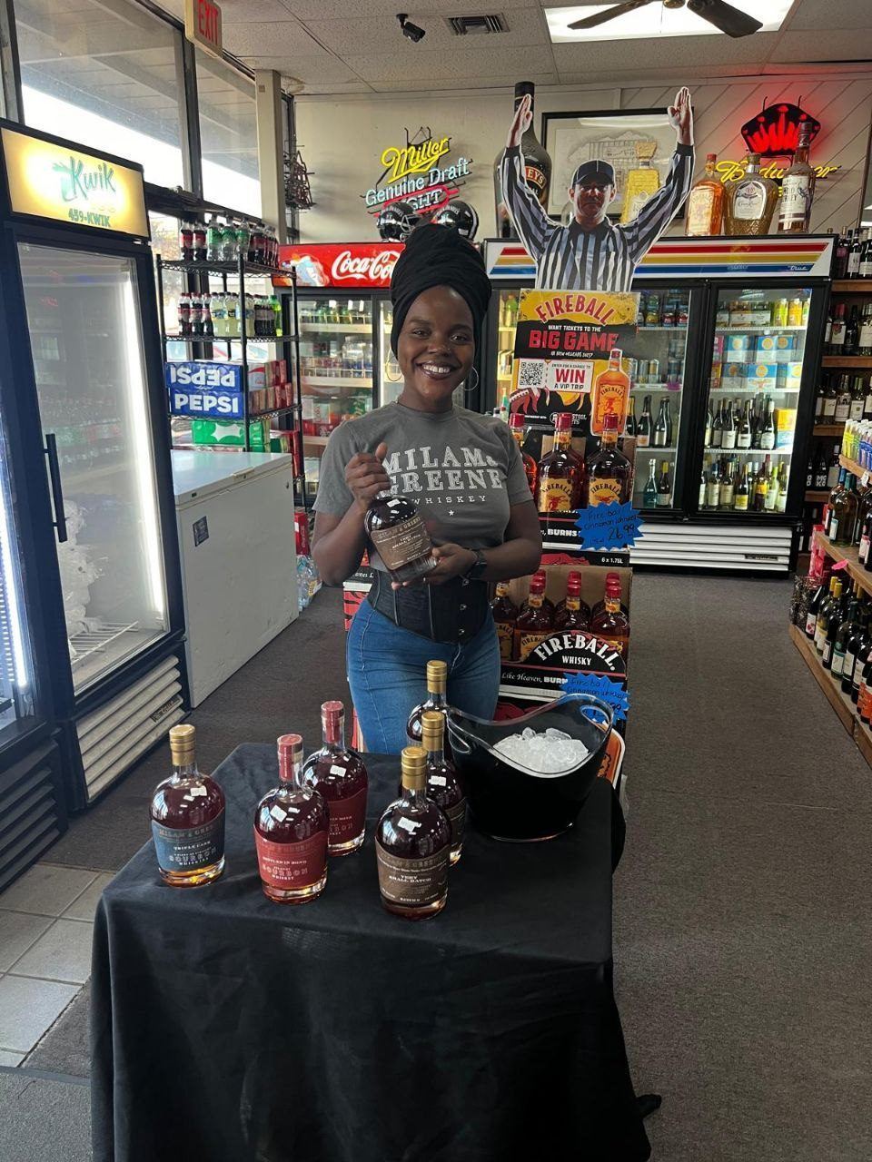 On-Site Activations — Milam & Greene whiskey lineup tasting with branded ambassador and ice bucket in front of a Fireball Whisky display