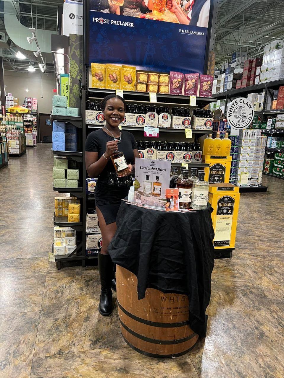 On-Site Activations — Coconut Cartel rum sampling on a whiskey barrel with Unrivaled Rum signage near a Paulaner beer display