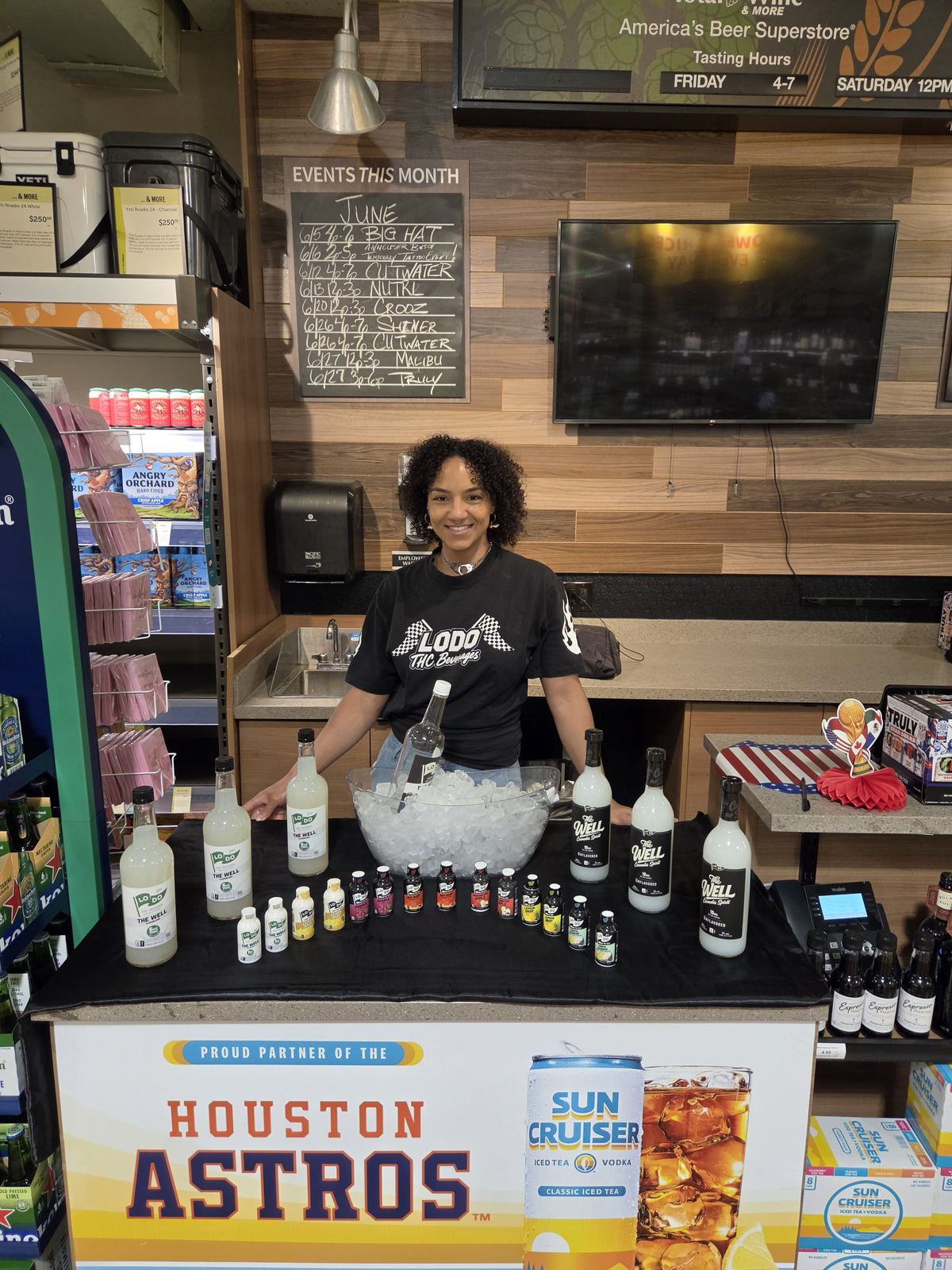 On-Site Activations — LoDo THC Beverages ambassador at Total Wine tasting bar with The Well bottle lineup and Houston Astros / Sun Cruiser display