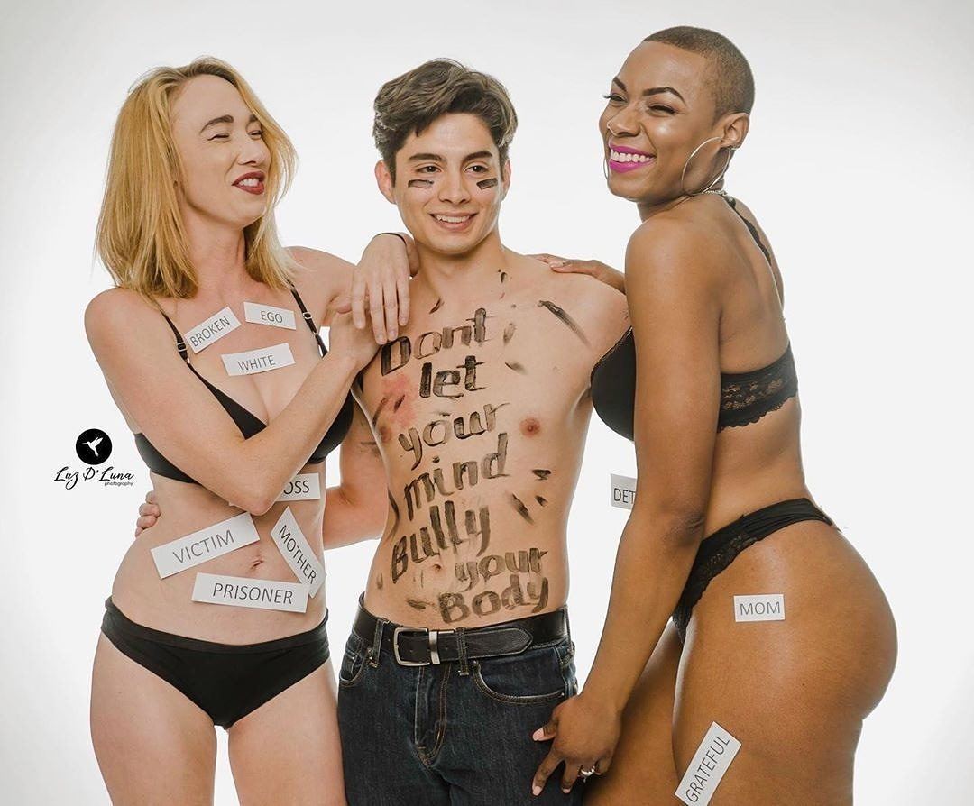 Photography — Three models in a body-positivity concept shoot with a painted torso message and paper word labels