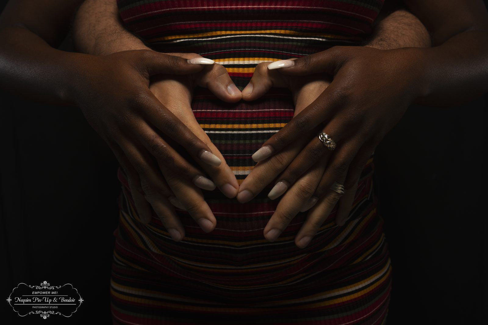 Photography — Two pairs of hands forming a heart over a striped dress in a pin-up studio shoot